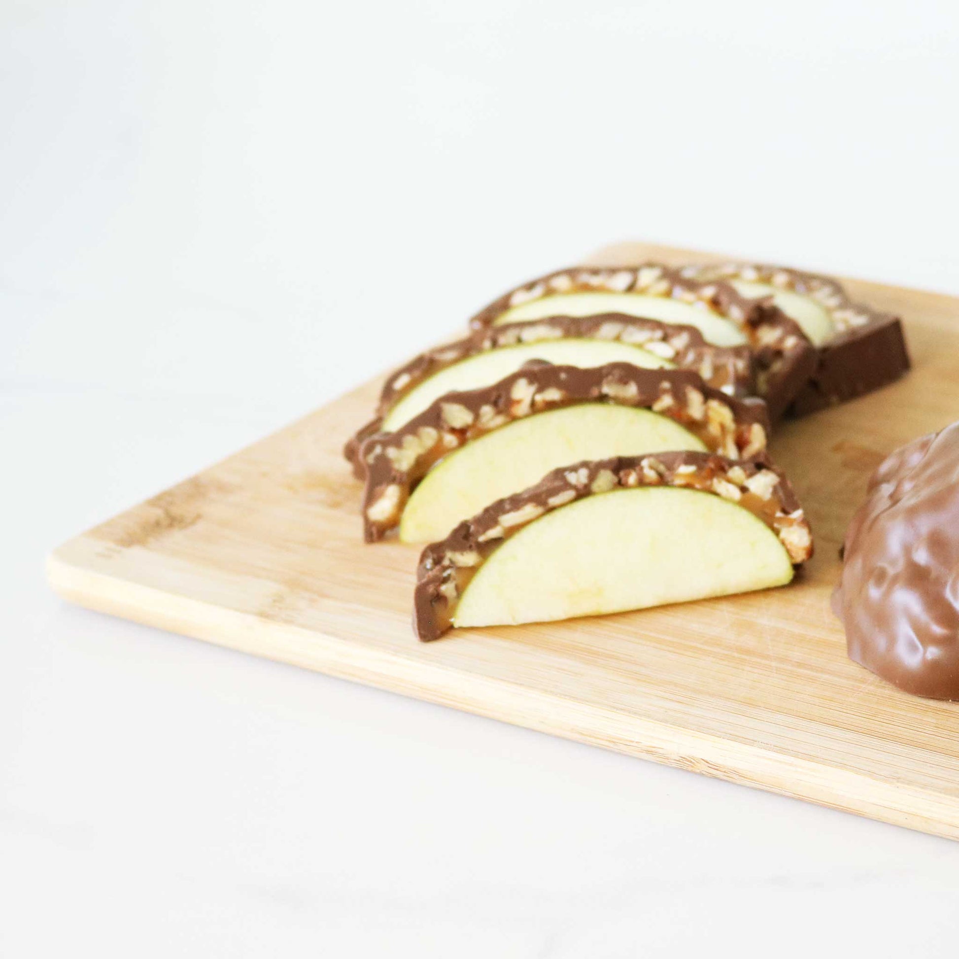 Caramel Apples with Nuts Sliced on a Cutting Board
