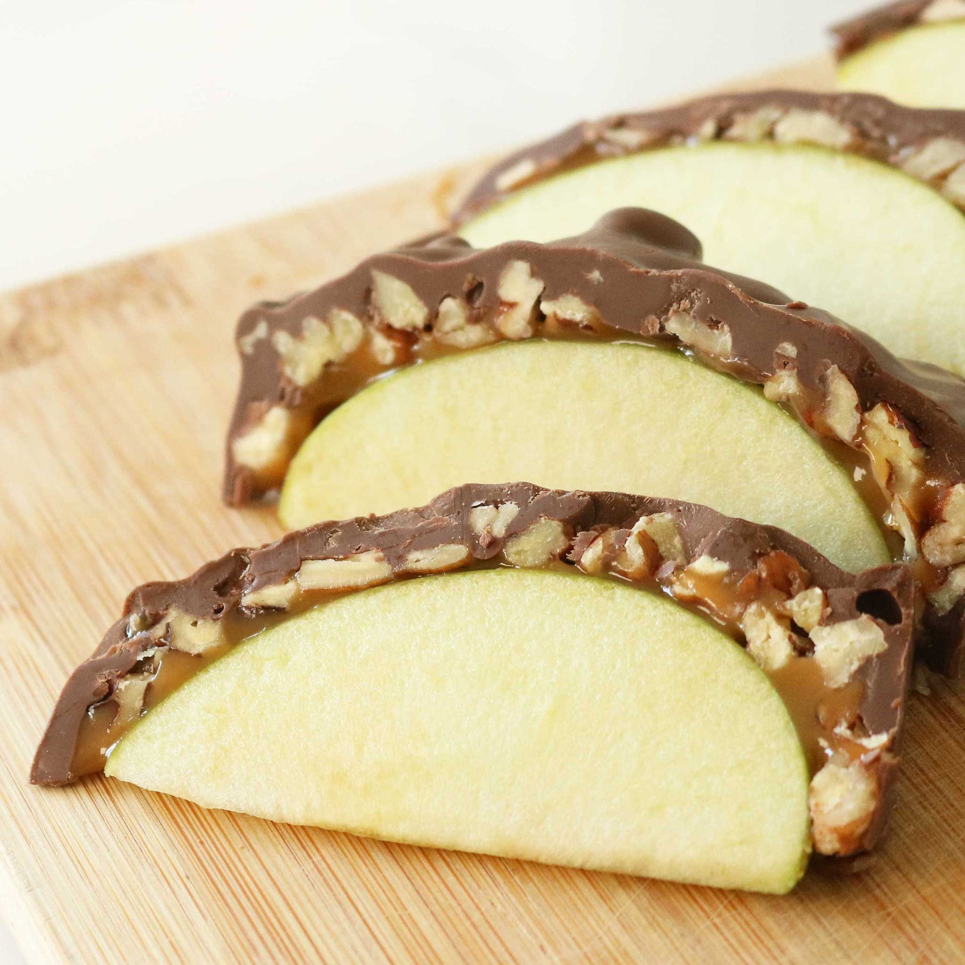 Caramel Apples with Nuts Sliced on a Cutting Board